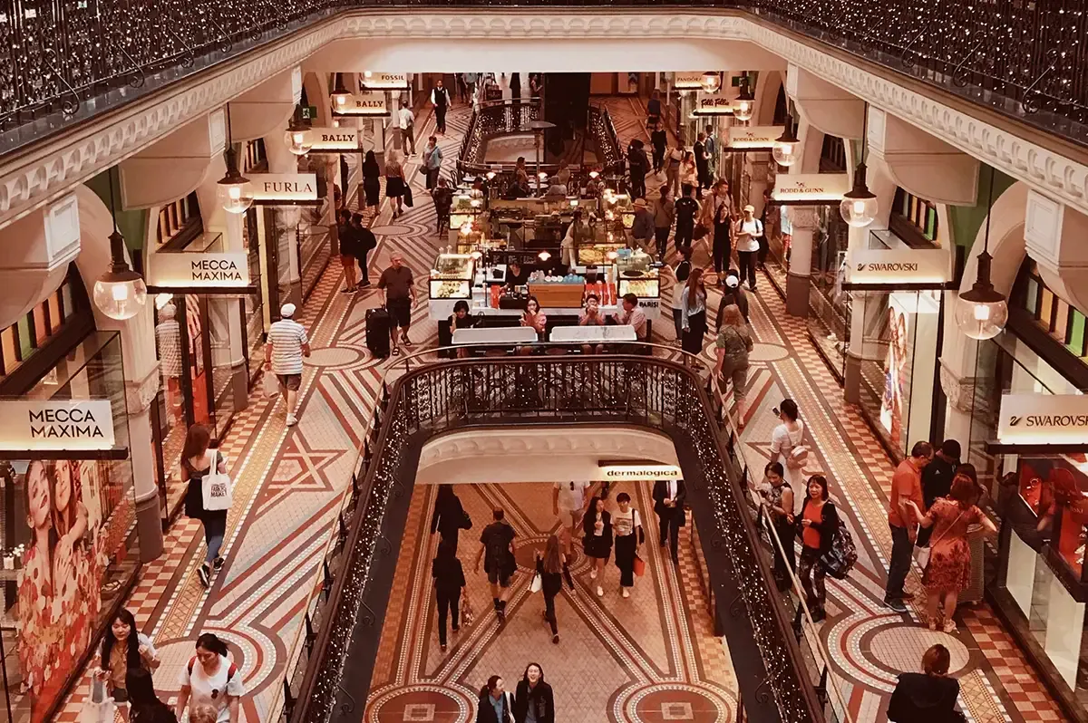 Galerie marchande sur plusieurs étages vue d'en haut, avec ses boutiques et ses clients