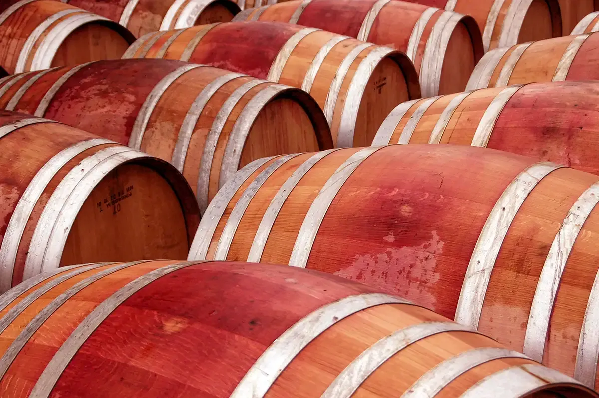 Rangées de barriques de chêne tachées de vin dans un chai